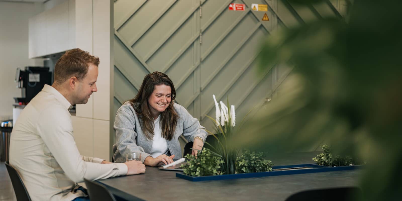 Twee collega's kijken naar AI ontwikkeling