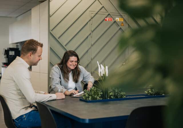 Twee collega's kijken naar AI ontwikkeling