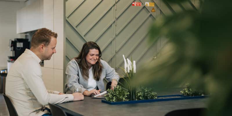 Twee collega's kijken naar AI ontwikkeling